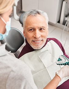 A man smiling while getting a denture impression