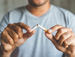 Closeup of man breaking cigarette