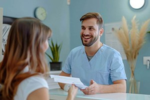 Dental receptionist talking to patient at front desk