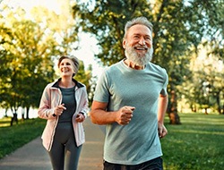 Older couple jogging outside, enjoying good health